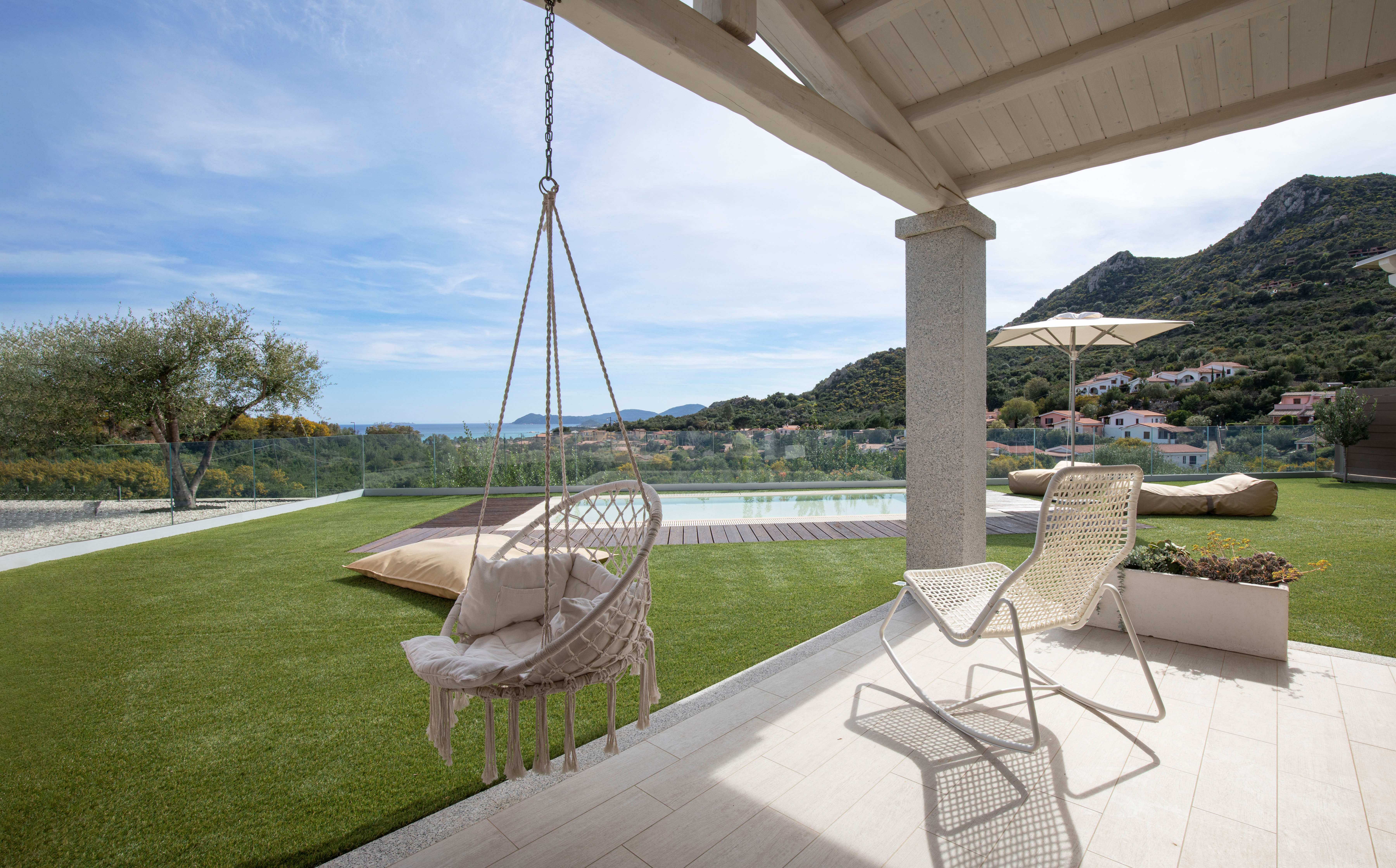 Veranda con amaca sospesa, giardino e plunge pool di un villino di Aura Residence